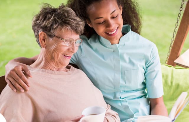 Professional caregiver helping elderly woman with daily activities