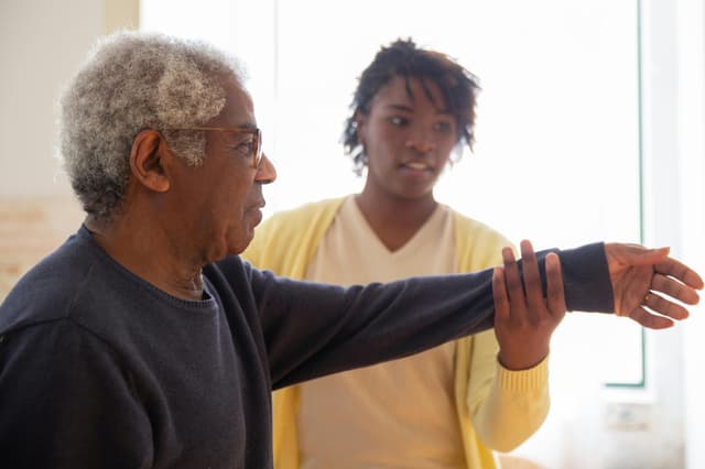 Caregiver assisting elderly patient with warm smile
